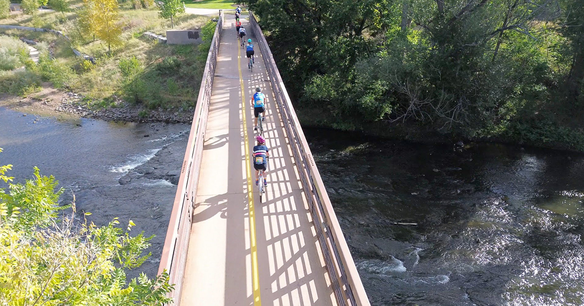 Denver Century Ride cyclists ride over bridge