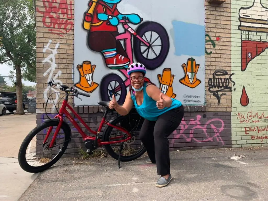 Woman bicyclist stands with her e-bike