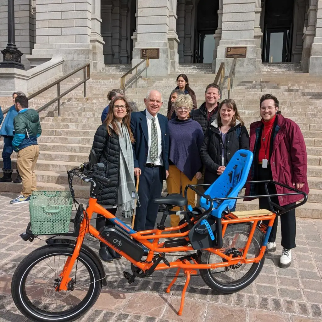 A group stands with an e-bike at the capitol