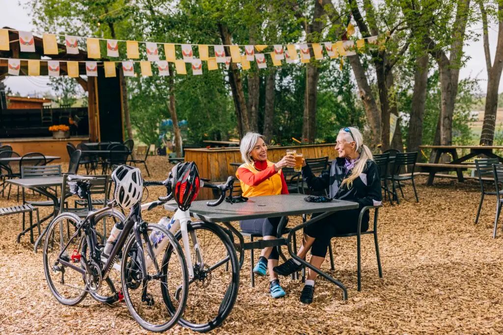 Two bicyclists toast outside a business