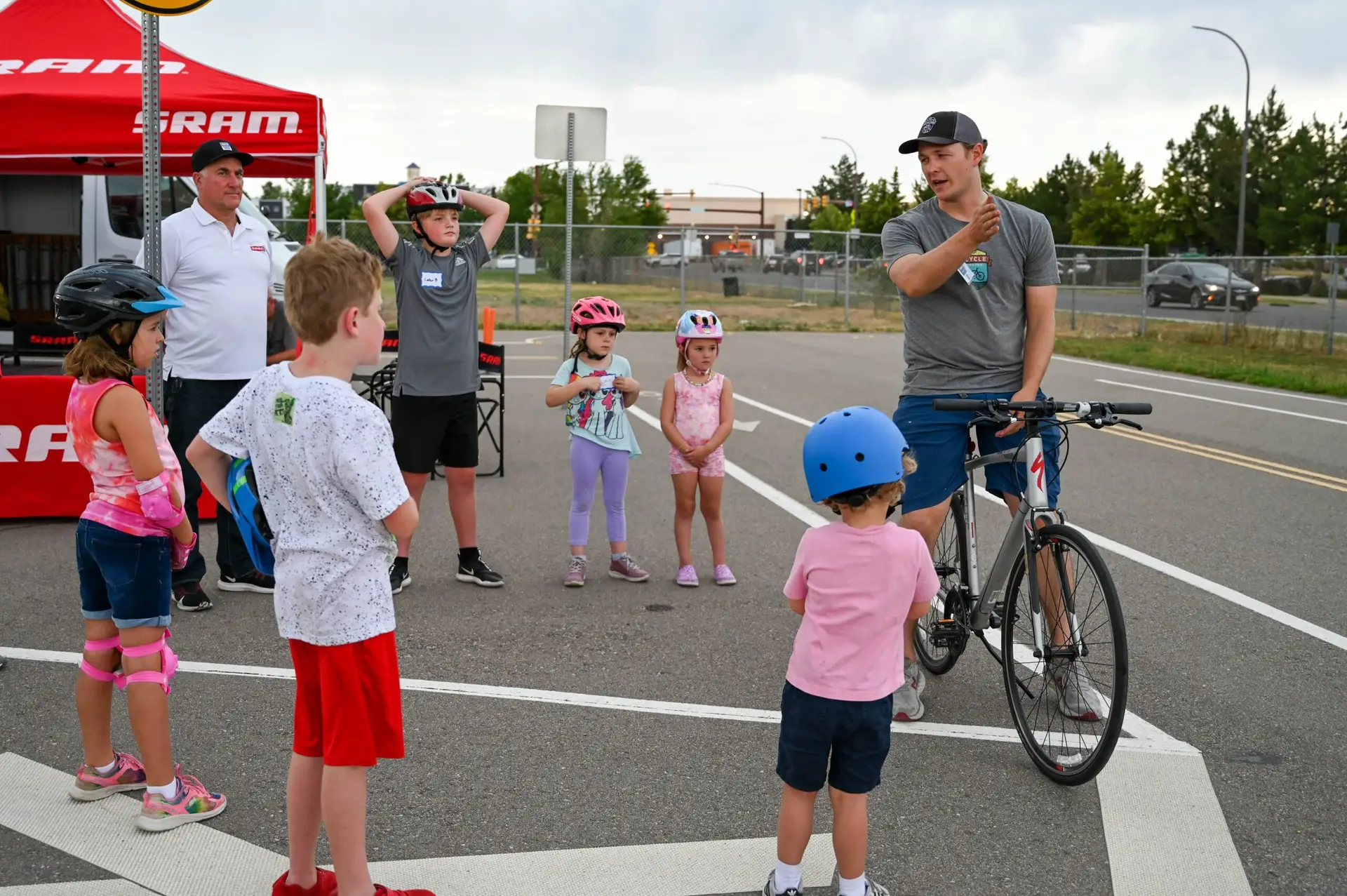 An instructor teaches a group of children about biking