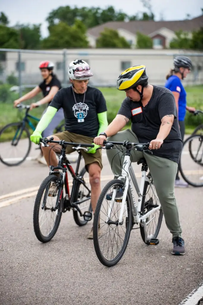 Instructor teaches adult how to ride a bike