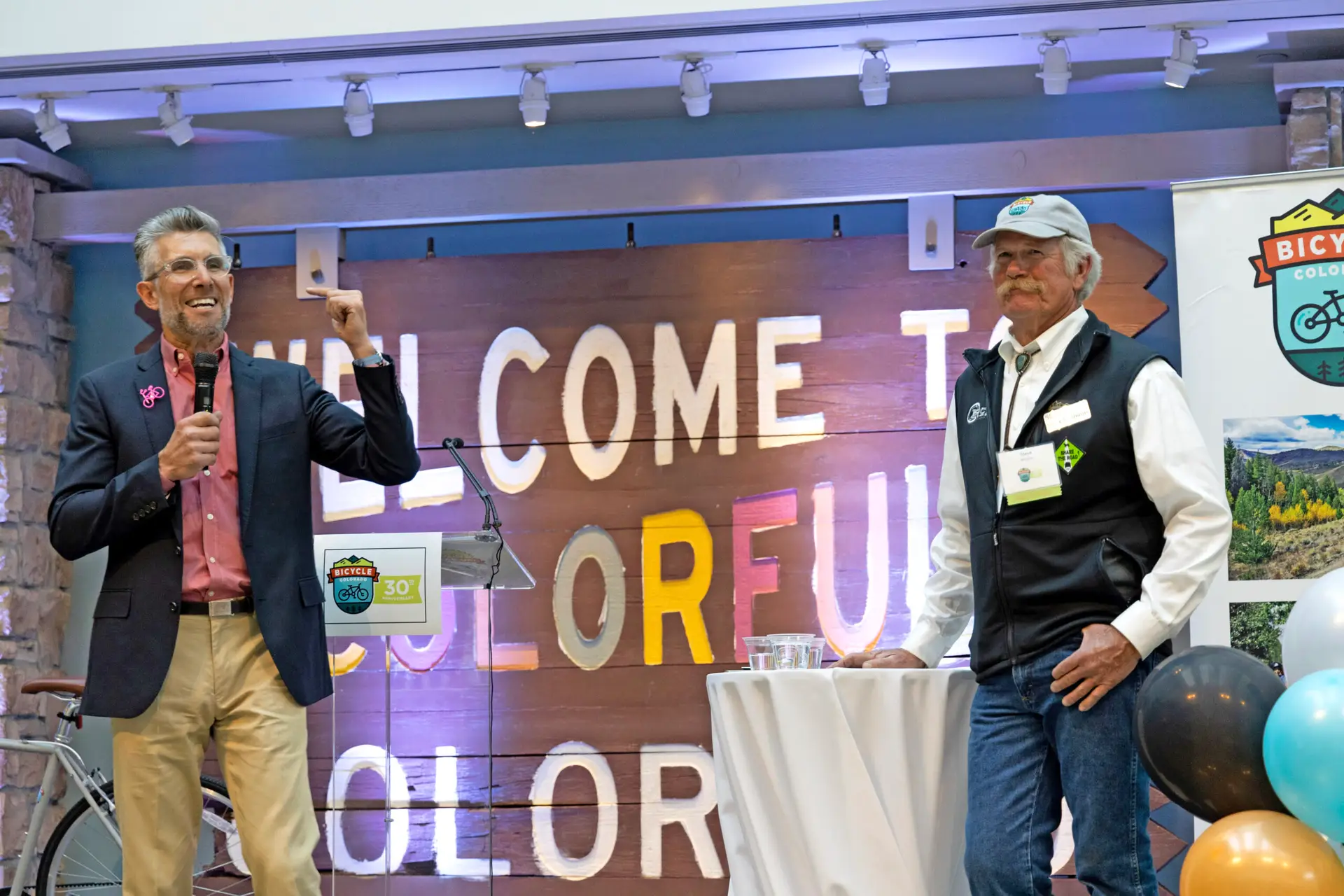 Two speakers at event stand on stage