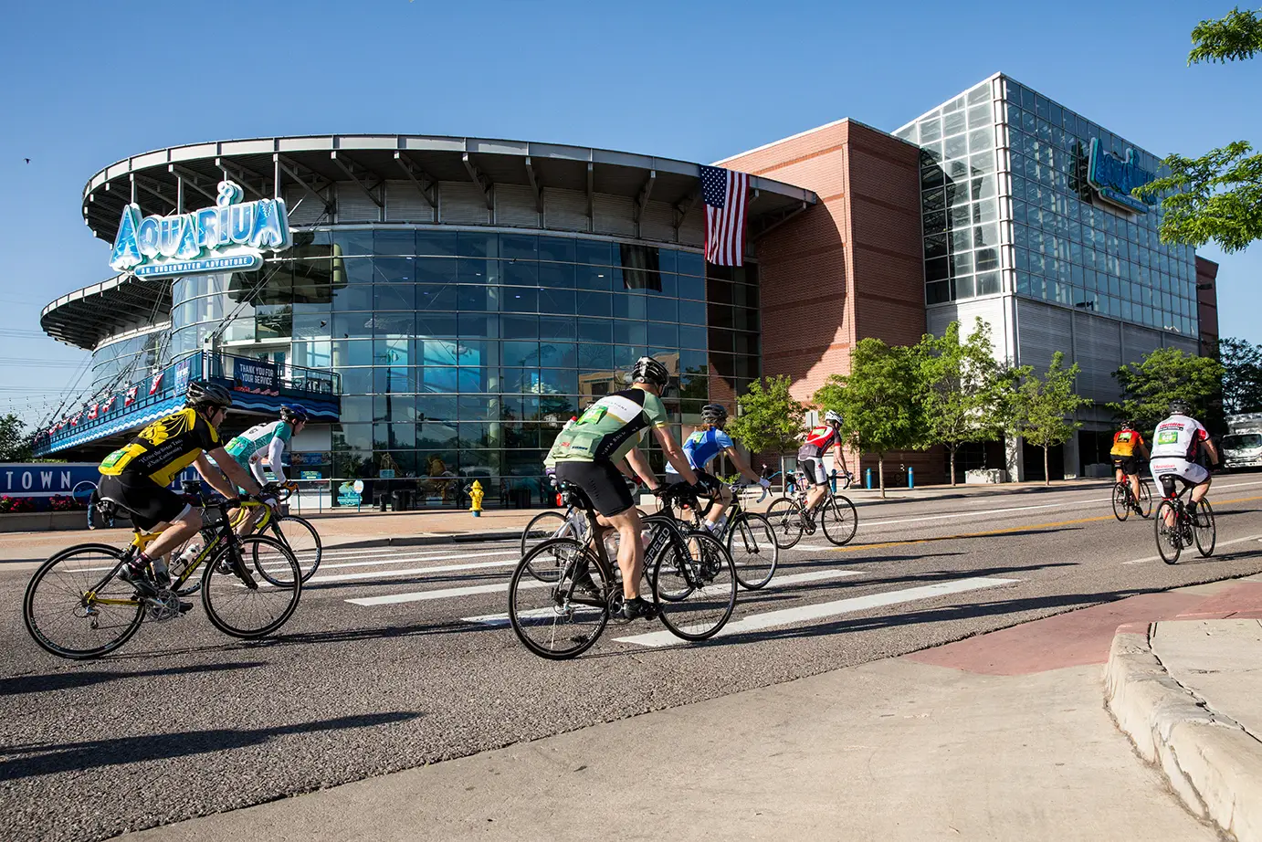 Bicyclists ride in front of the aquarium