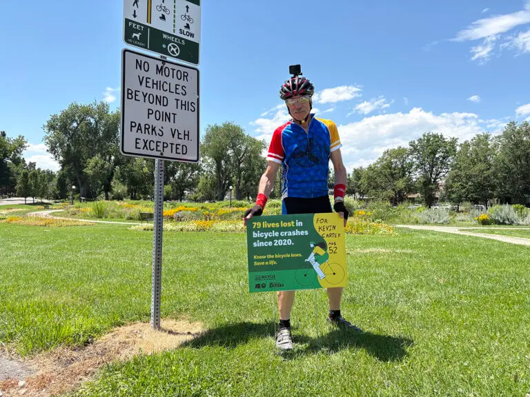 A bicyclist advocate stands with a sign