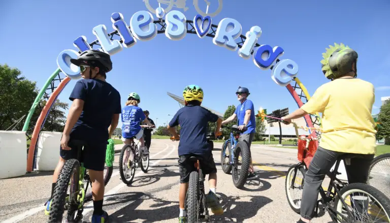 Ollie's Bike Ride parade sign with bike riders