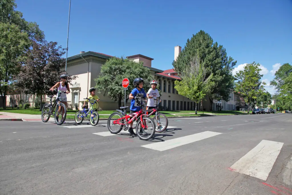 Family of bicyclists cross the road