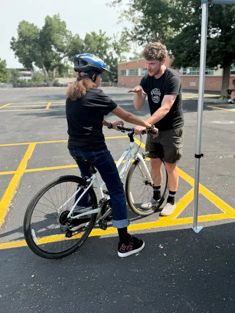 Educator teaches a student how to ride a bike
