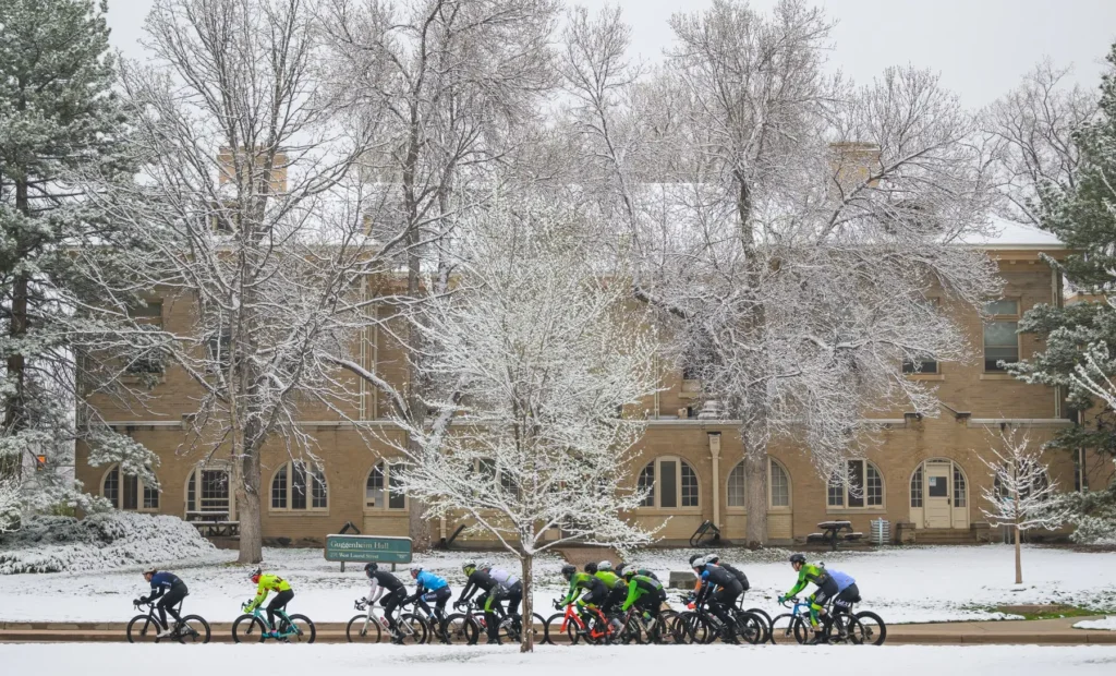 Bicyclists ride together on a college campus