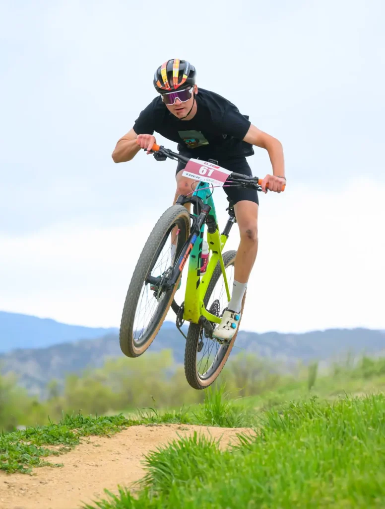 A bicyclist jumps on their bike