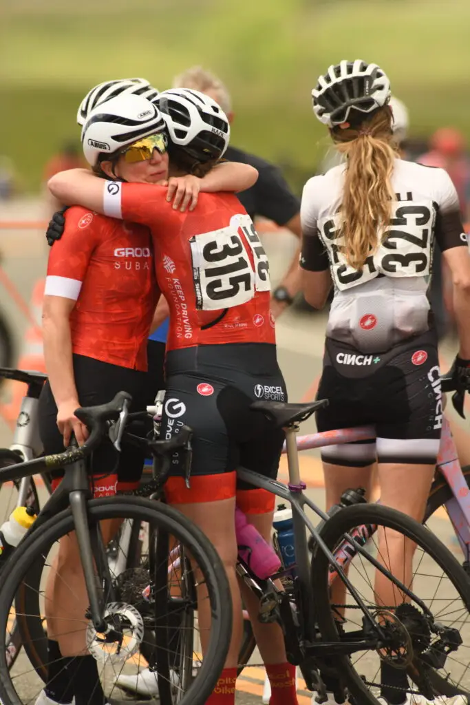 Bicyclists hug each other